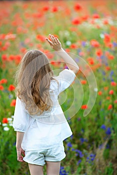 Happy kid girl portrait with clenched fists outdoors. Back view