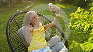 Happy kid girl take selfie on mobile phone in the park outdoor