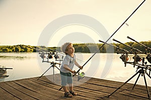 Happy kid having fun. Angling child with fishing rod on wooden pier