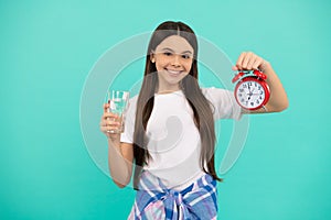 happy kid hold glass of water and clock to stay hydrated and keep daily water balance, thirst.