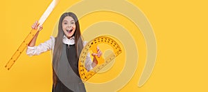 happy kid hold math protractor and ruler in school on yellow background, education. Horizontal isolated poster of school