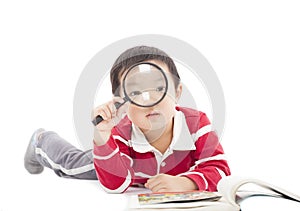 Happy kid is holding magnifying glass to explore