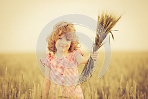 Happy kid holding wheat