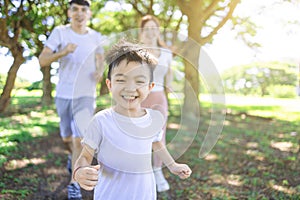 Happy kid Jogging with parents in the city park