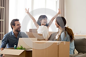 Happy kid jumping out of box laughing packing with parents