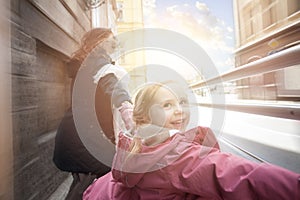 Happy kid laughing with mother outdoor, motion