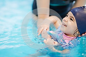 Happy kid learning to swim at school