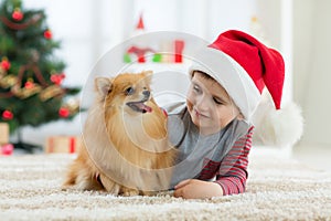 Happy kid little boy and dog as their gift at Christmas. Christmas interior