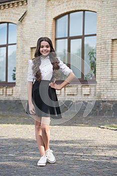 Happy kid with long hair wear formal school fashion dress code schoolyard outdoors, uniform