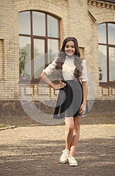 Happy kid with long hair wear formal school fashion dress code schoolyard outdoors, uniform