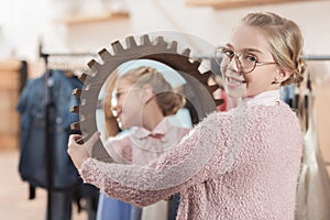 happy kid looking at camera with mirror in her hands at store