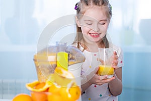 Happy kid making orange juice