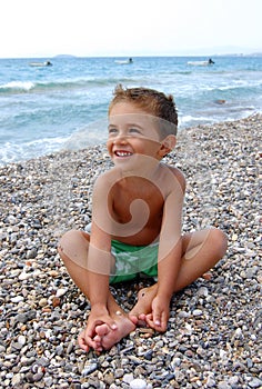 Happy kid on pebbly beach