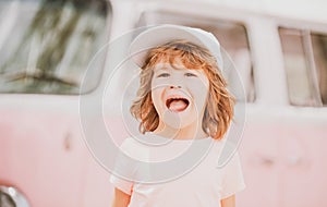 Happy kid in pink clothes car. Child hippie. Happy toddler child having fun for travel in retro minivan.