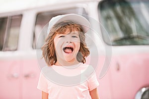 Happy kid in pink clothes car. Child hippie. Happy toddler child having fun for travel in retro minivan.