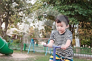 Happy kid play teeter totter in playground, color tone, shallow