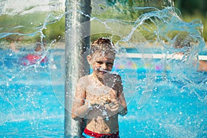 Happy kid playing in blue water of swimming pool on a tropical r