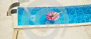 Happy kid playing in blue water of swimming pool on a tropical r