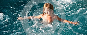 Happy kid playing in outdoor swimming pool on hot summer day. Kids learn to swim. Child in water. Children play in