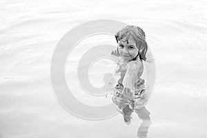 Happy kid playing in swimming pool. Child water games. Family vacation and summer activity.