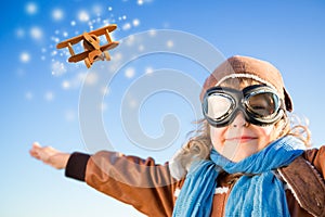 Happy kid playing with toy airplane in winter