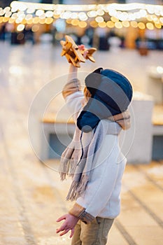 Happy kid playing with vintage wooden airplane outdoors. Portrait of children against the lights and sky.