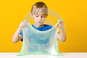 Happy kid plays with handmade toy slime. Cute boy doing experiment scientific method