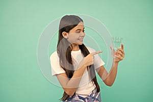 happy kid pointing finger on glass of water to keep daily water balance in body, hydration.