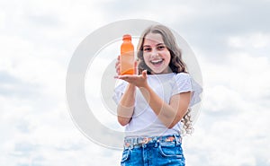 happy kid presenting juice or water in bottle for refreshing, vitamin