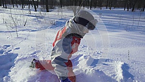 Happy kid run on winter park on deep snow