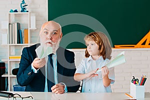 Happy kid in school break. Teacher with pupil with airplanes. Education, teachering, elementary school.