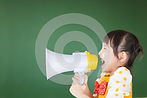 Happy kid shouts something into the megaphone