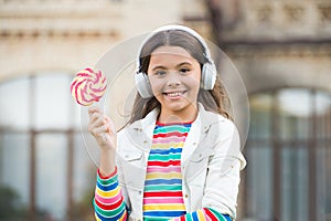 Happy kid singing sweet candy mic. Happy childhood. Kid child headphones holding lollipop candy. Happy kid with candy