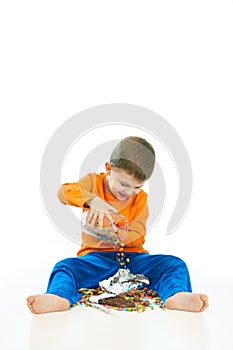 Happy kid spilling sweets on the floor sitting