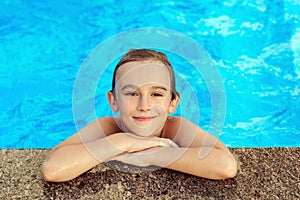 Happy kid swimming in outdoors pool. Summer vacation concept. Water games and water fun for kids