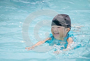 Happy kid swimming in the pool