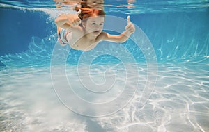 Happy kid swims in pool underwater, active kid swimming underwater, playing and having fun, Children water sport