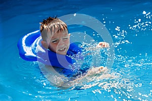 Happy kid in vest at swimming pool . Chilhood, leisure, swimming theme. Boy In Life Jacket.