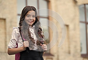 Happy kid wear long wavy hair with back to school look in schoolyard, salon, copy space