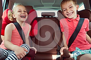 Happy kids, adorable girl with her brother sitting together in m