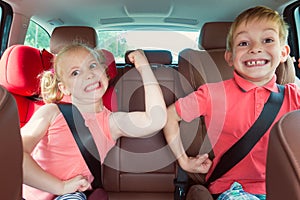 Happy kids, adorable girl with her brother sitting together in m