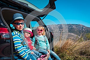 Happy kids-boy and girls- enjoy travel by car in moutains, family vacation