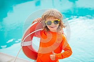 Happy kids boy play in swim guard or lifeguard in the sea. Funny child boy with lifebuoy show thumbs up sign.