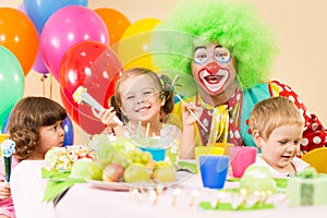 Happy kids celebrating birthday party with clown