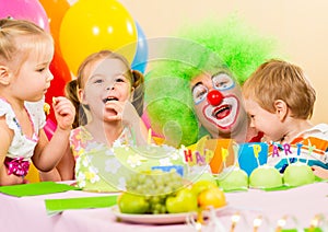 Happy kids celebrating birthday party with clown