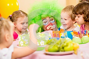 Happy kids celebrating birthday party with clown