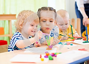 Happy kids doing arts and crafts in day care centre