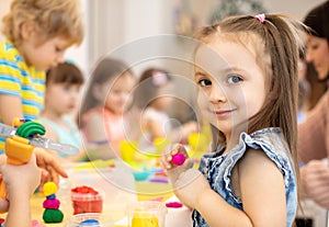 Happy kids doing arts and crafts in day care centre photo