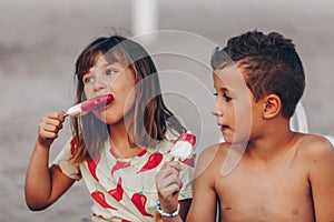 Happy kids eating ice cream on the beach