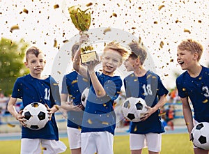 Happy kids in elementary school sports team celebrating soccer succes in tournament final game